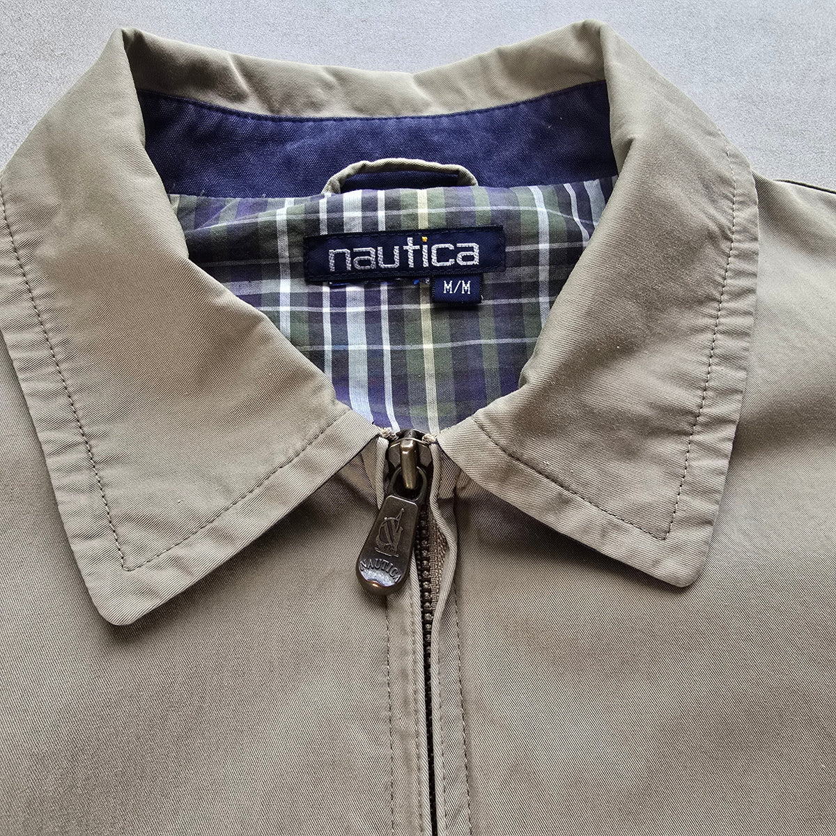 DEEP VINTAGE beige Nautica Harrington jacket with a plaid lining and branded zipper pull, size medium.