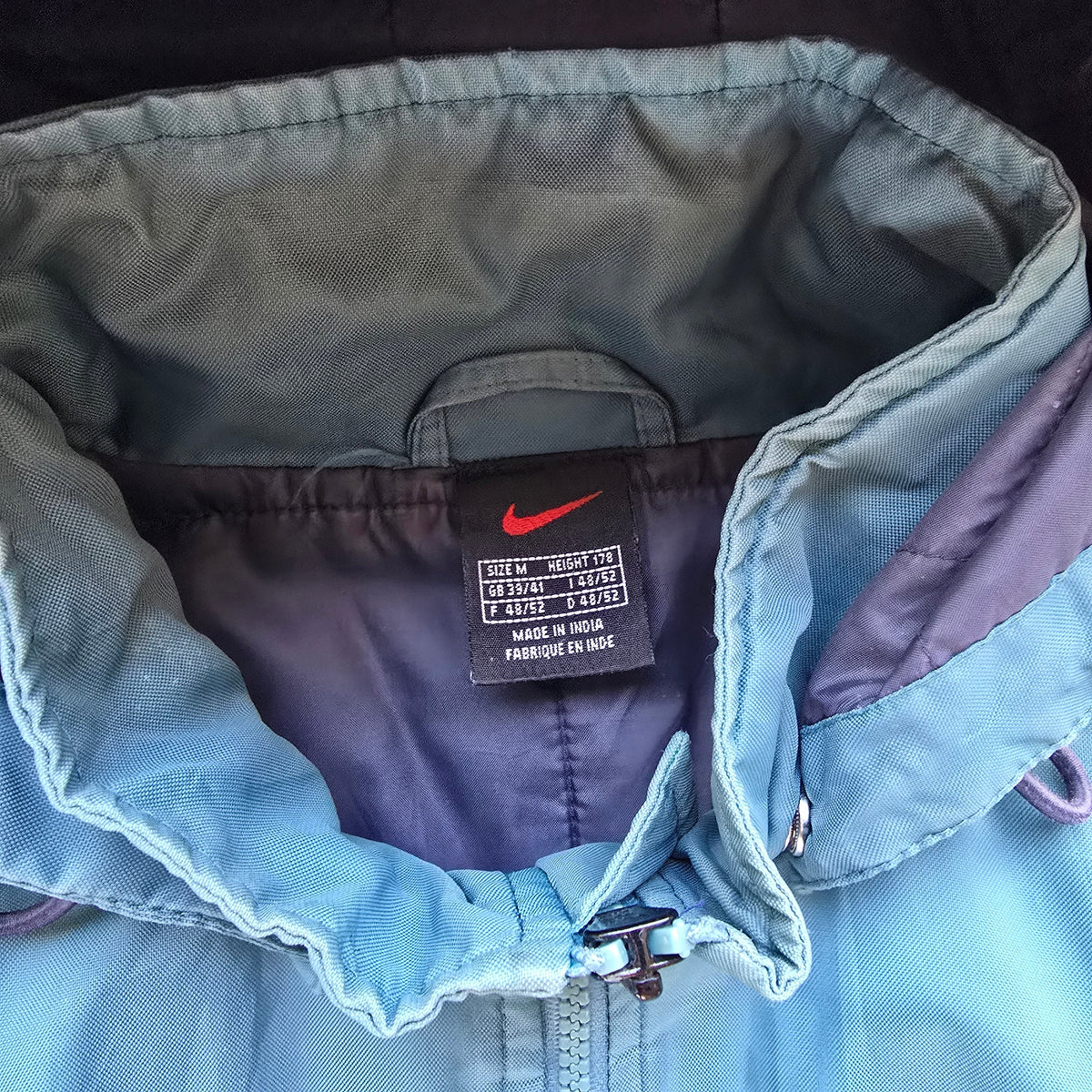 DEEP VINTAGE 90s Nike jacket collar detail showing the brand tag and detachable hood mechanism