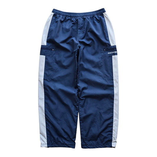 DEEP VINTAGE navy blue Nike track pants with white side stripes, elastic drawstring waist, and side cargo pockets.